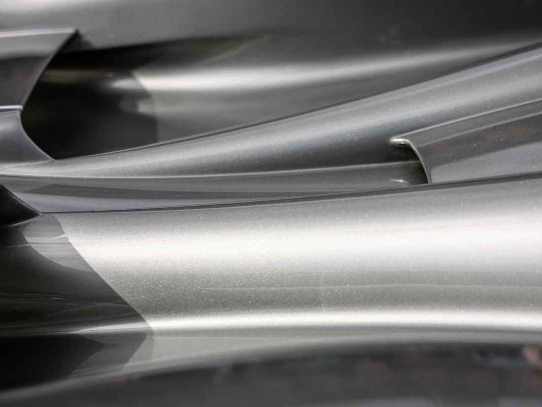 Işığı yansıtan, kıvrımlı parlak paslanmaz metal yüzeyler